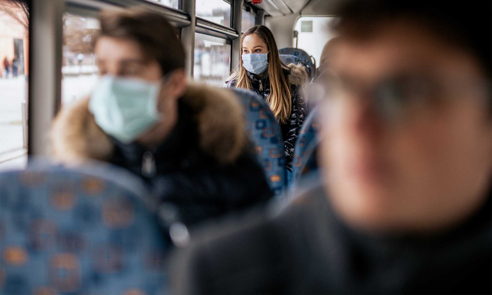 Bus riders wearing masks.